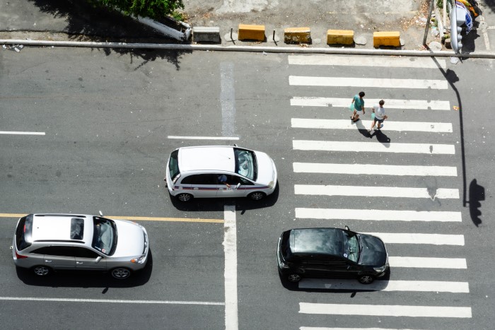 coches circulando por la carretera y peatones cruzando